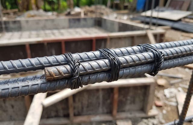 Penyambungan lapping length pada besi 10 sni yang diikat menggunakan kawat bendrat pada proyek konstruksi bangunan.