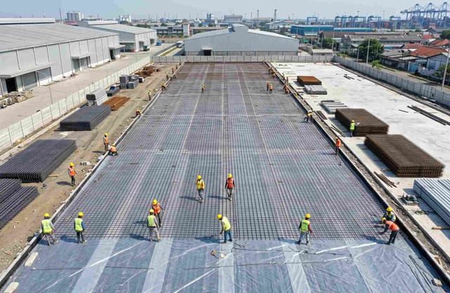 Pemasangan wiremesh M8 lembar di atas lapisan plastik cor untuk persiapan pengecoran lantai gudang logistik